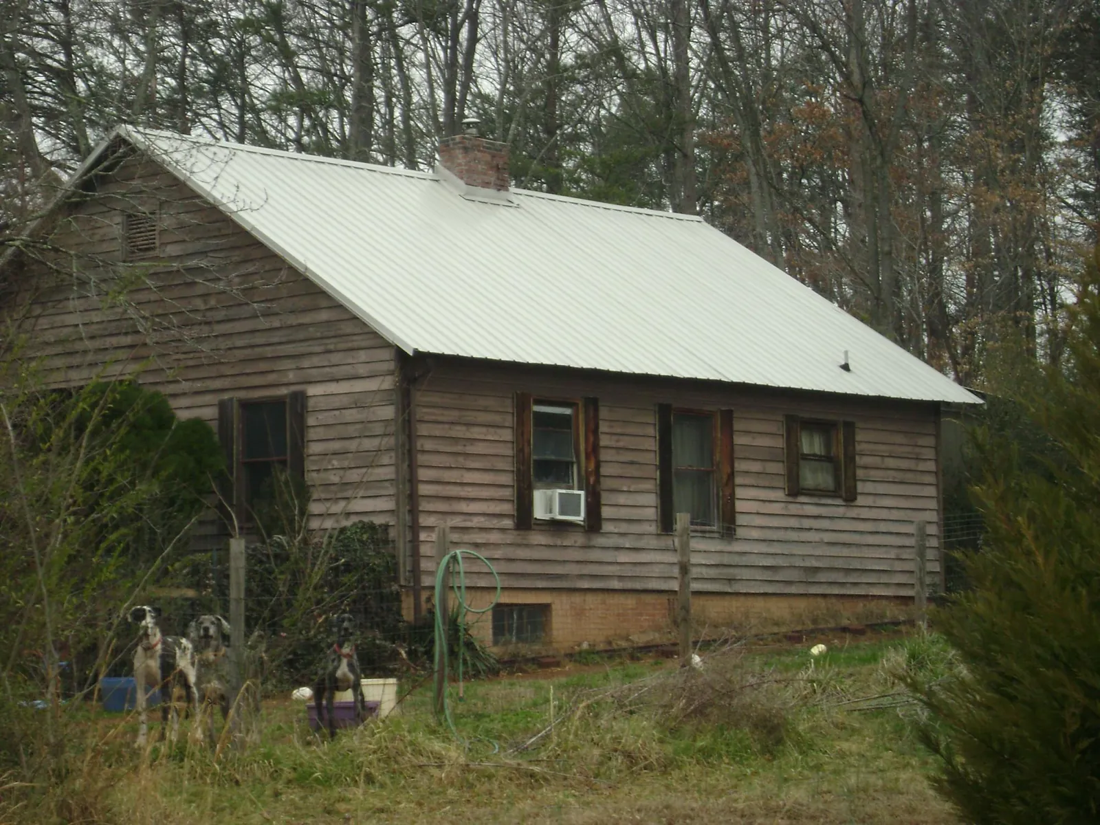 White metal roof on an old wood sided farmhouse, from a Metal Roof Installation job in Eddyville